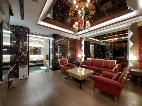 a living room with red furniture and a chandelier at Elysees Motel in Toufen