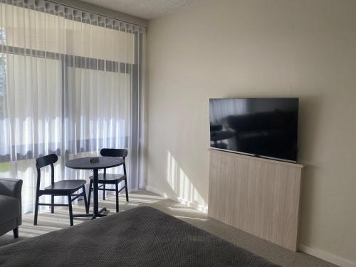 a hotel room with a television and a table and chairs at Toronto Hotel in Toronto