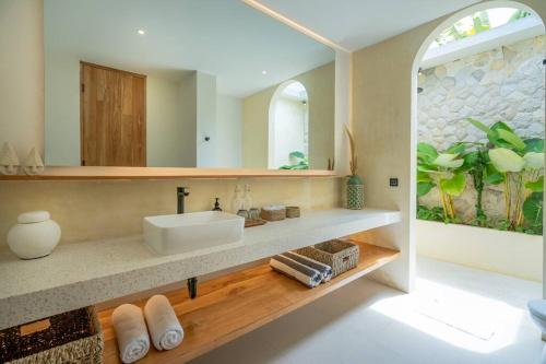 ein Bad mit einem Waschbecken und einem Spiegel in der Unterkunft New 4 BDR Villa Mejan in Canggu