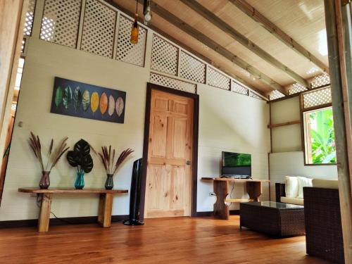 sala de estar con puerta de madera y sofá en Casa Siri de Cahuita, en Cahuita