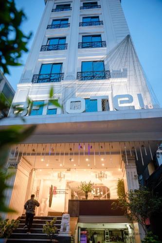 ハノイにあるHanoi B Hotel & Travel - 5 mins Hoan Kiem lakeの建物の前に立っている男性