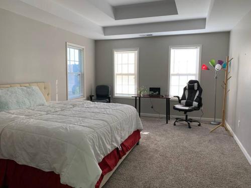een slaapkamer met een bed, een bureau en stoelen bij Cheerful 4-Bedroom home. in Riverdale