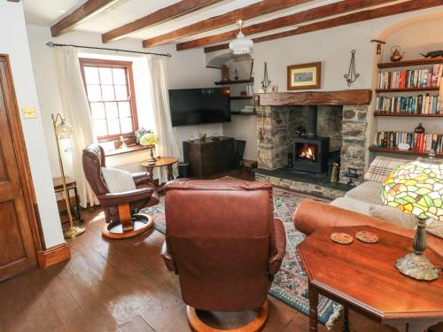 a living room with a couch and a fireplace at Penywhelp House in Cardigan