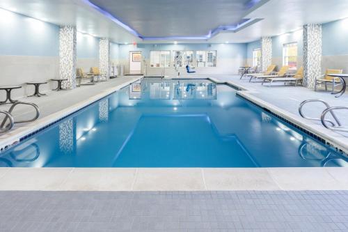Holiday Inn Express & Suites Williamsburg, an IHG Hotel في وليامزبورغ: مسبح كبير مع ماء أزرق في مبنى