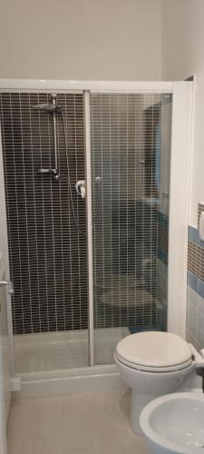 a bathroom with a toilet and a glass shower at L'angolo degli ulivi in Marcellano