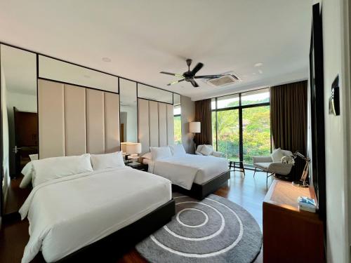 ein Schlafzimmer mit 2 Betten und ein Wohnzimmer in der Unterkunft Merissa Luxury Private Pool Villa in Pantai Cenang
