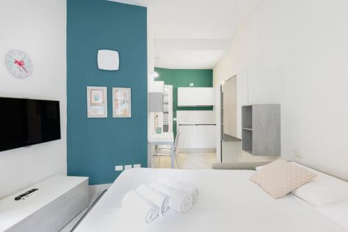 ein Schlafzimmer mit einem weißen Bett und einer blauen Wand in der Unterkunft Easylife - Comodo Studio in Corso di Porta Romana in Mailand