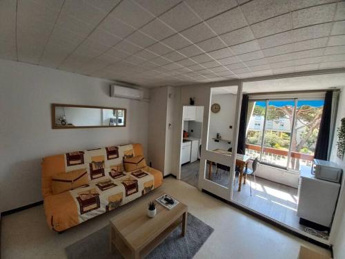 ein großes Wohnzimmer mit einem Bett und einem Sofa in der Unterkunft studio parking privé climatisation plage proche in La Grande-Motte