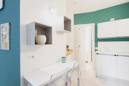 uma cozinha com armários brancos e uma parede azul em Easylife - Comodo Studio in Corso di Porta Romana em Milão