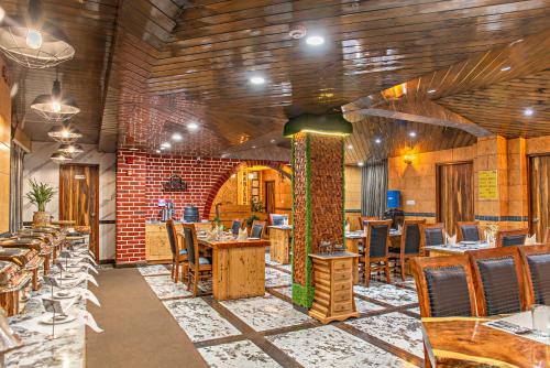 a restaurant with wooden ceilings and tables and chairs at Ram Cottage Chail 3 BHK villa with Lawn & Parking in Chail