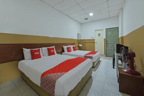 a hotel room with two beds and a television at OYO 90794 Maple Hotel in Skudai