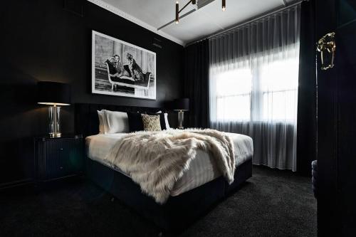 a black bedroom with a large bed with a blanket at Ruby by Whiskey June in Maryborough