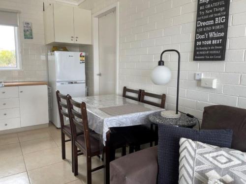 Una cocina con una mesa con sillas y un refrigerador. en Salt On Warley, en Cowes