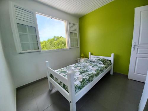 1 dormitorio con cama y ventana en KORN LAMBIS en Sainte-Luce