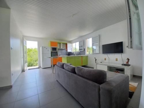 a living room with a couch and a kitchen at KORN LAMBIS in Sainte-Luce