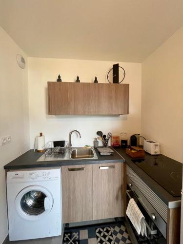 une cuisine avec une machine à laver et un évier dans l'établissement Studio Neuf à 10min Plage & Centre-Ville + Garage, à Ajaccio