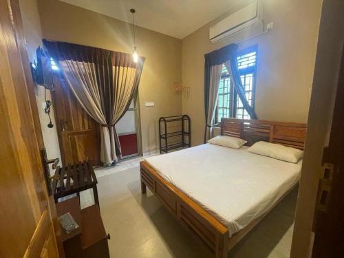 a bedroom with a bed and a window at Catray Inn in Kalmunai