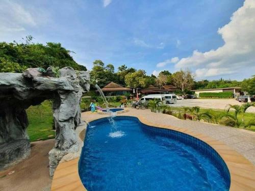 a swimming pool in a yard with a waterfall at สงขลาคีรี รีสอร์ท SongkhlaKeeree Resort in Ban Khao Rup Chang