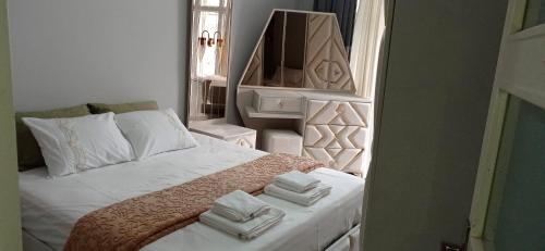 Un dormitorio con una cama blanca con toallas. en Grand Bazaar Crossing apartment, en Estambul
