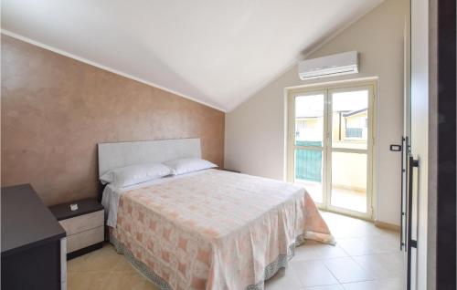 um quarto com uma cama e uma grande janela em Beautiful Apartment In Caulonia Marina With Kitchenette em Caulonia Marina