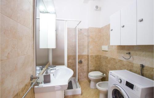y baño con lavabo y lavadora. en Beautiful Apartment In Caulonia Marina With Kitchenette, en Caulonia Marina