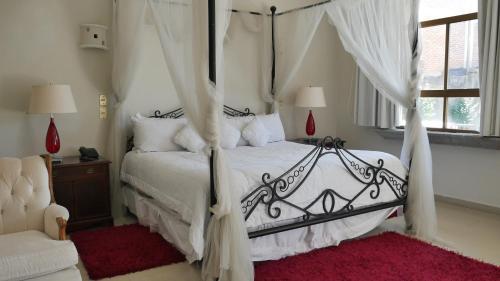1 dormitorio con cama con dosel y alfombra roja en Hotel Hacienda las Higueras, en Tepic