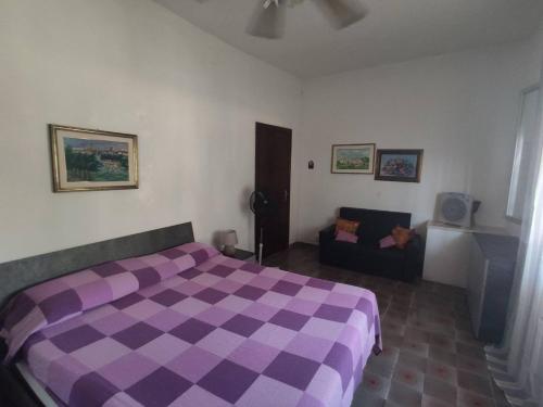 トッレ・ラピッロにあるCasa Vacanze Salentoのベッドルーム(紫色のベッド1台、ソファ付)
