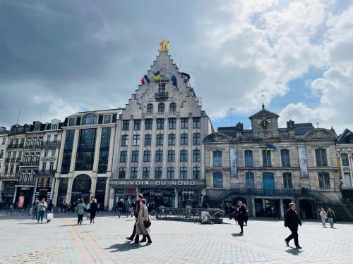 a group of people walking in front of a large building at Holiday Inn Express Lille Centre by IHG in Lille