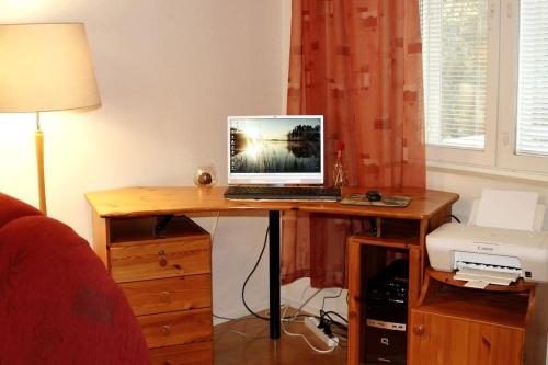 a desk with a laptop computer on top of it at Retrohenkinen kaksio Nurmeksen keskustassa. in Nurmes