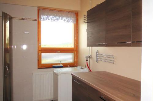 een kleine keuken met een raam, een wastafel en een aanrecht bij Retrohenkinen kaksio Nurmeksen keskustassa. in Nurmes