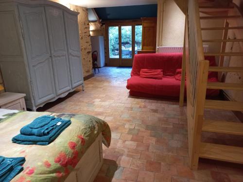 Habitación con cama y sofá rojo en Chambre d'hôtes à proximité du circuit des 24h, en Ruaudin