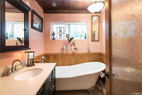 baño grande con bañera y lavamanos en Cabin Spa Getaway Near Lakes and Resorts, en Crestline