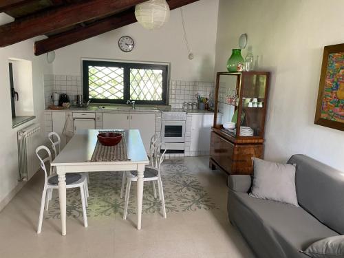 cocina y sala de estar con mesa y sofá en Adamasseria Case Vacanza, en Collecorvino
