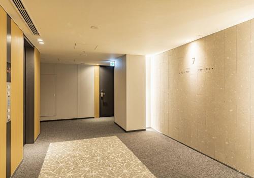 an empty hallway with a wall with a sign on it at Tokyu Stay Sapporo in Sapporo
