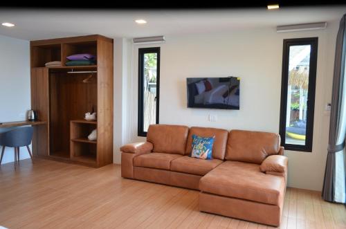 a living room with a brown couch and a table at JP Resort Koh Tao in Koh Tao