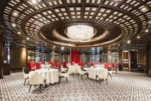 a dining room with tables and chairs and a large ceiling at Holiday Inn Shanghai Hongqiao West, an IHG Hotel in Qingpu