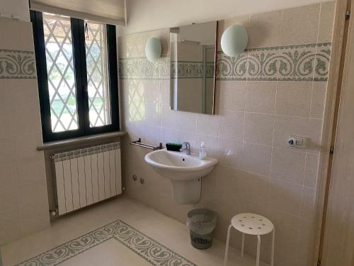 baño con lavabo, espejo y ventana en Adamasseria Case Vacanza, en Collecorvino