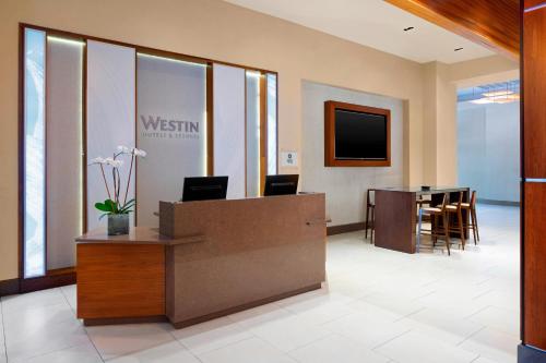 an office lobby with a reception desk and a table at The Westin Crystal City Reagan National Airport in Arlington