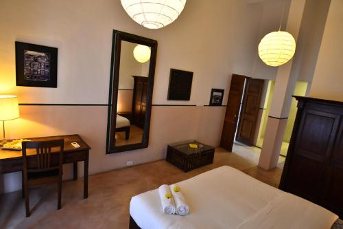 a room with a bed and a desk and a mirror at La Closerie - Bay of Bengal in Puducherry