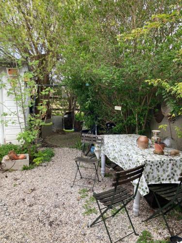 une table et des chaises dans une cour arborée dans l'établissement Emcée B&B, à Kapellen