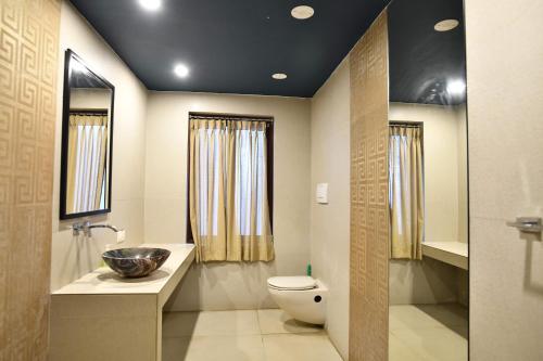 a bathroom with a toilet and a sink at La Closerie - Bay of Bengal in Puducherry