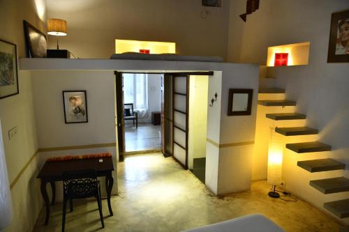 a room with a staircase with a table and a stair case at La Closerie - Bay of Bengal in Puducherry