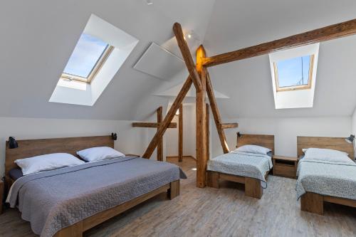 a bedroom with two beds and two windows at Vila Antik in Nové Hrady
