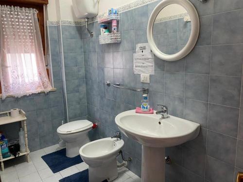 uma casa de banho com um lavatório, um WC e um espelho. em Casa alloggio em Scalea