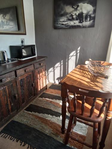 a room with a wooden table and a wooden chair at Howick Greendale 4 Self Catering Units Solar & Battery Back-Up in Howick