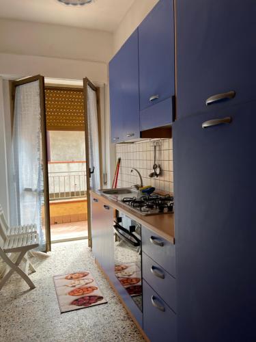 cocina con armarios azules y encimera en La Casa del Professore, en Nicotera Marina