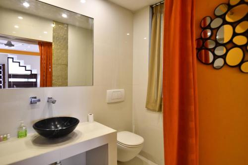 a bathroom with a black sink and a toilet at La Closerie - Bay of Bengal in Puducherry