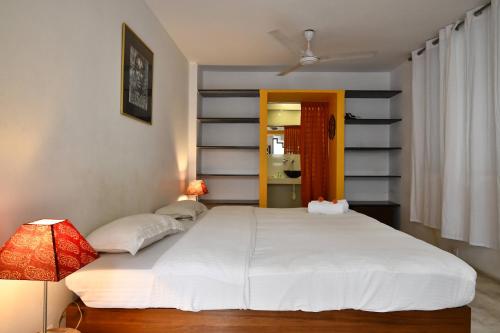 a bedroom with a large white bed in a room at La Closerie - Bay of Bengal in Puducherry