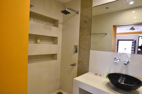 a bathroom with a black sink and a shower at La Closerie - Bay of Bengal in Puducherry