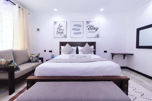 - une chambre avec un grand lit et un canapé dans l'établissement Arabel's Place Riverside Villas, à Nanyuki